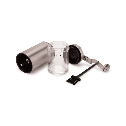 Manual burr grinder taken apart: body, grounds container, crank handle and cleaning brush