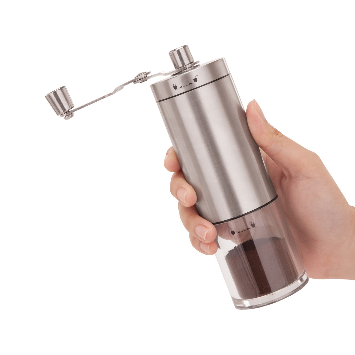 Hand holding the manual burr grinder full of ground coffee
