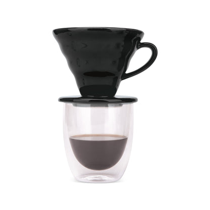 Black pour over dripper on a double-wall glass of freshly brewed coffee