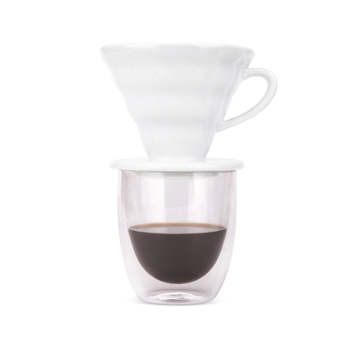 White pour over dripper on a double-wall glass of freshly brewed coffee