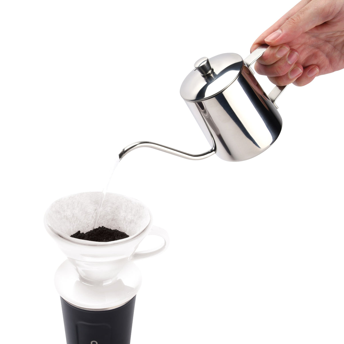 Pouring water from a gooseneck kettle over ground coffee in the white pour over dripper
