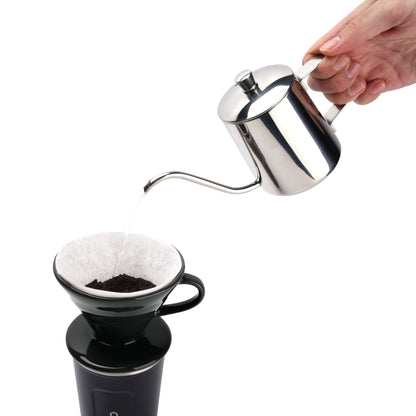 Pouring water from a gooseneck kettle over ground coffee in the black pour over dripper